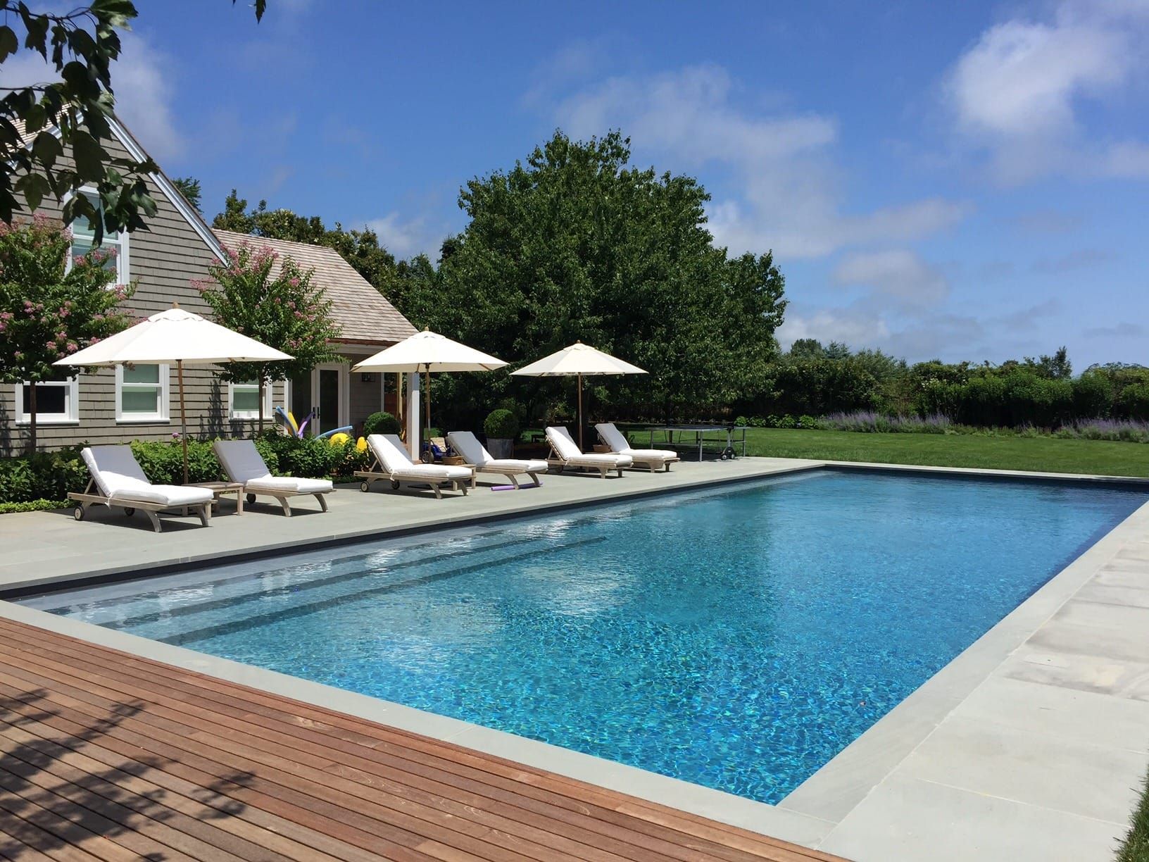 A Binder Pools swimming pool with stone decking and lounge chairs